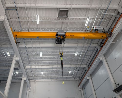 An overhead crane inside a warehouse or factory.
