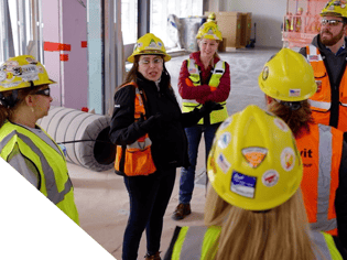 Image of people in construction gear appearing to be speaking to one another