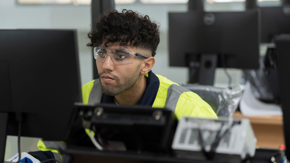 A construction professional sits in front of a computer monitor. A construction professional sits in front of a computer monitor.